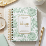 Floral notebook on a desk with a pen and flowers